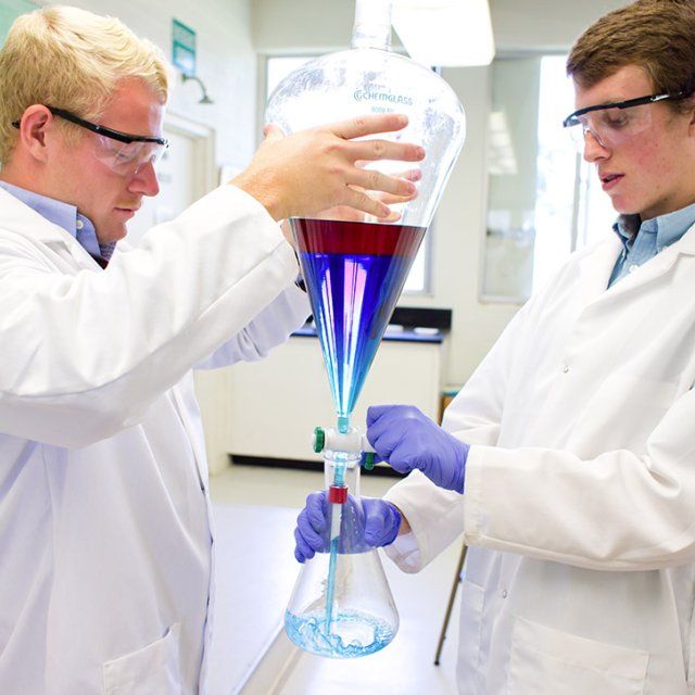 Two male students experimenting with two liquids during a research lab