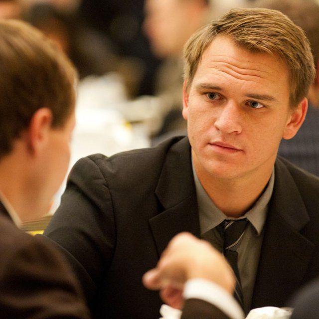 Two male students wearing suits deep in conversation at an MBA executive development event