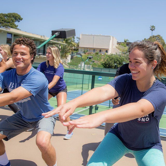Students bust a move in an outside aerobic dance class.