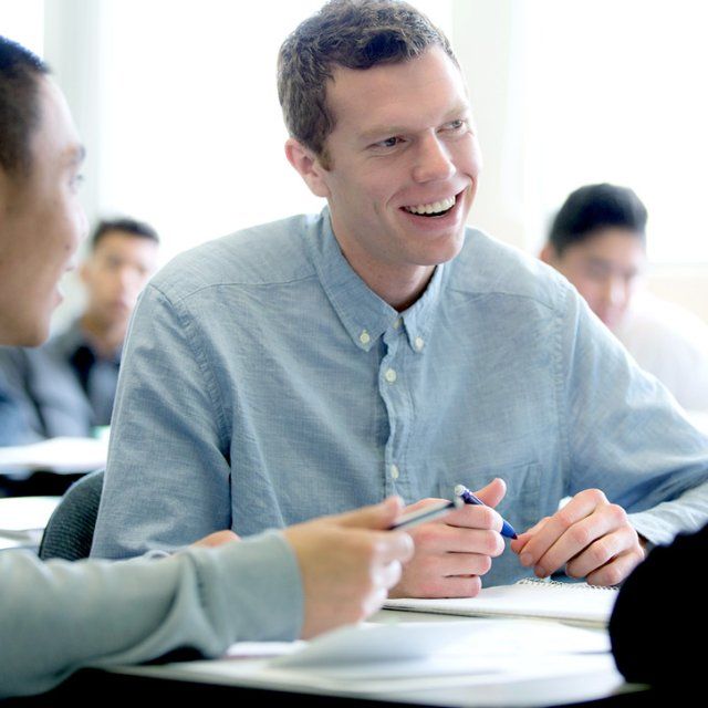 A student smiles while working in group in class.