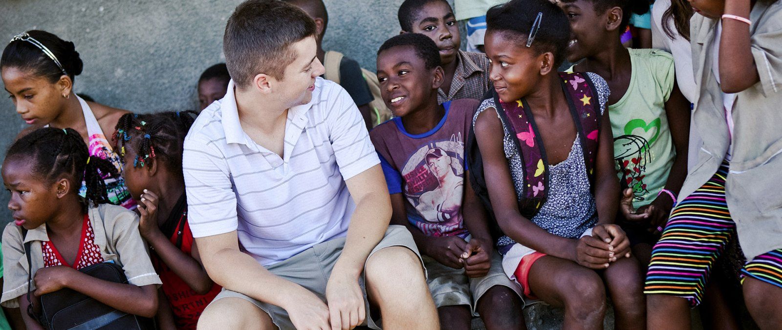 A PLNU student interacts with a group of children on a Loveworks trip in Madagascar.