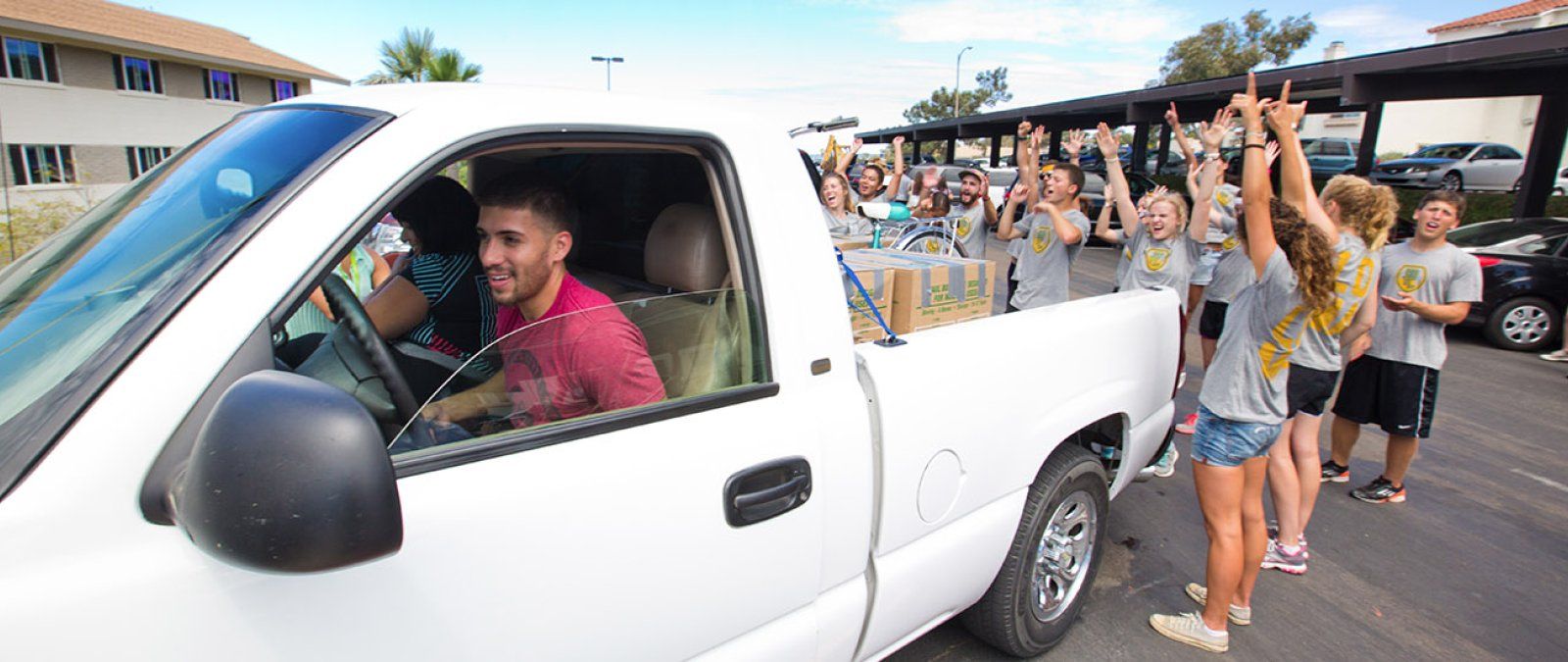 Current PLNU students eagerly help new freshmen unload their car.