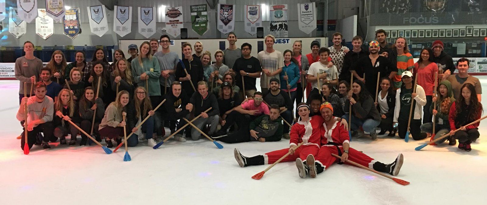 A large group of PLNU transfer students play broomball at a TAG event
