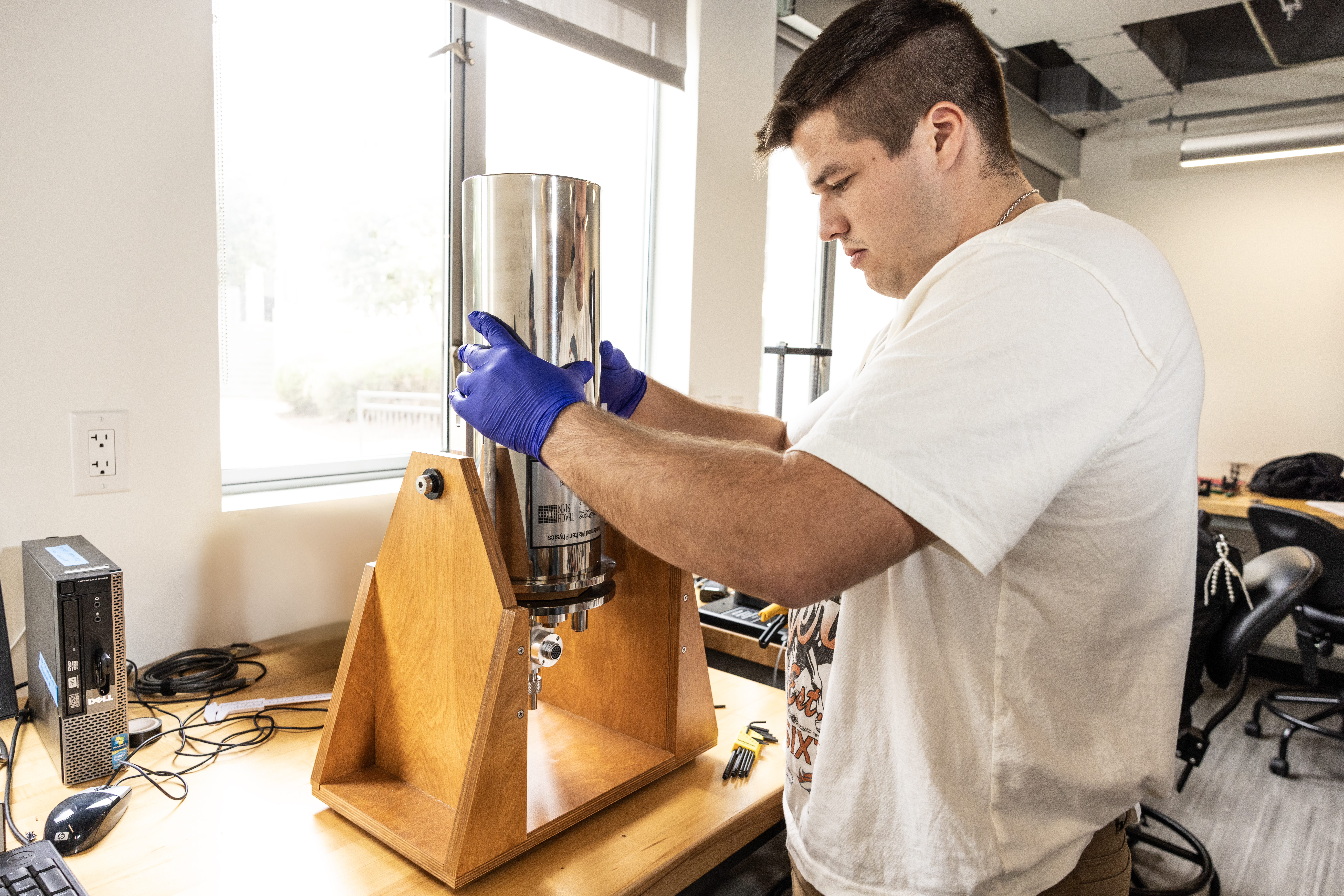 PLNU engineering student operates laboratory equipment during a materials testing experiment.