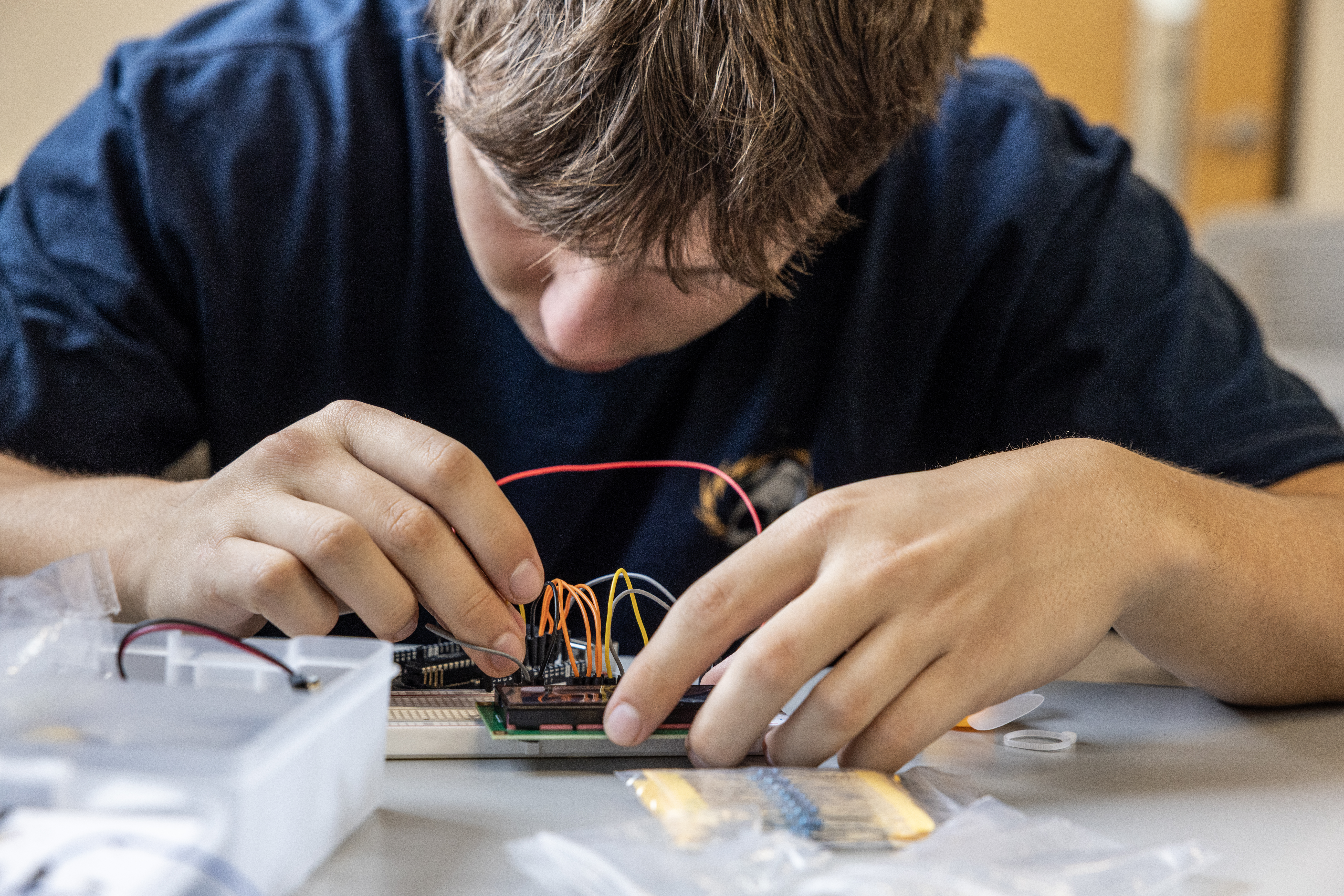 PLNU engineering student assembles and tests an electronic circuit on a breadboard.