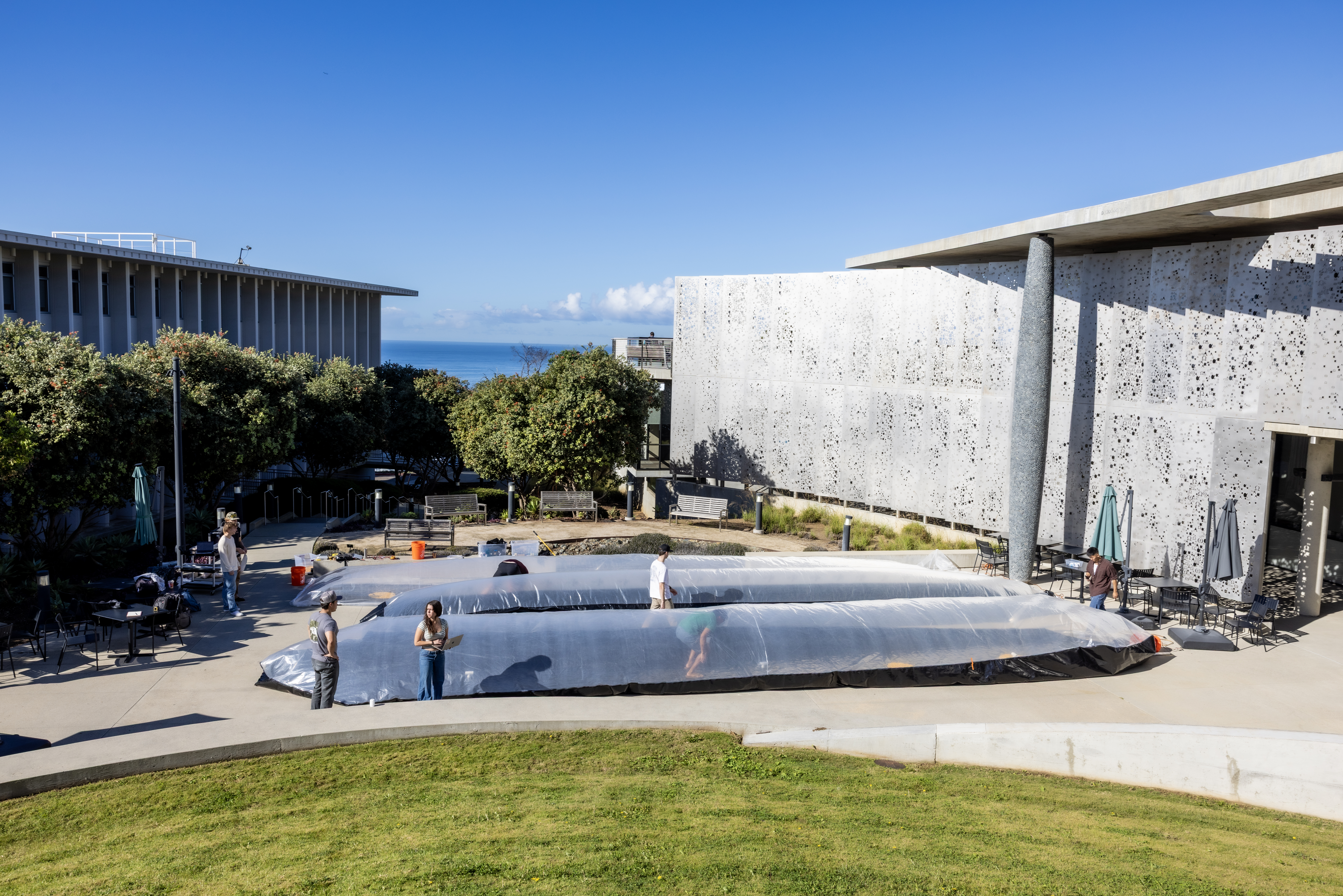 PLNU engineering students work on a large engineering design project in an outdoor campus setting.