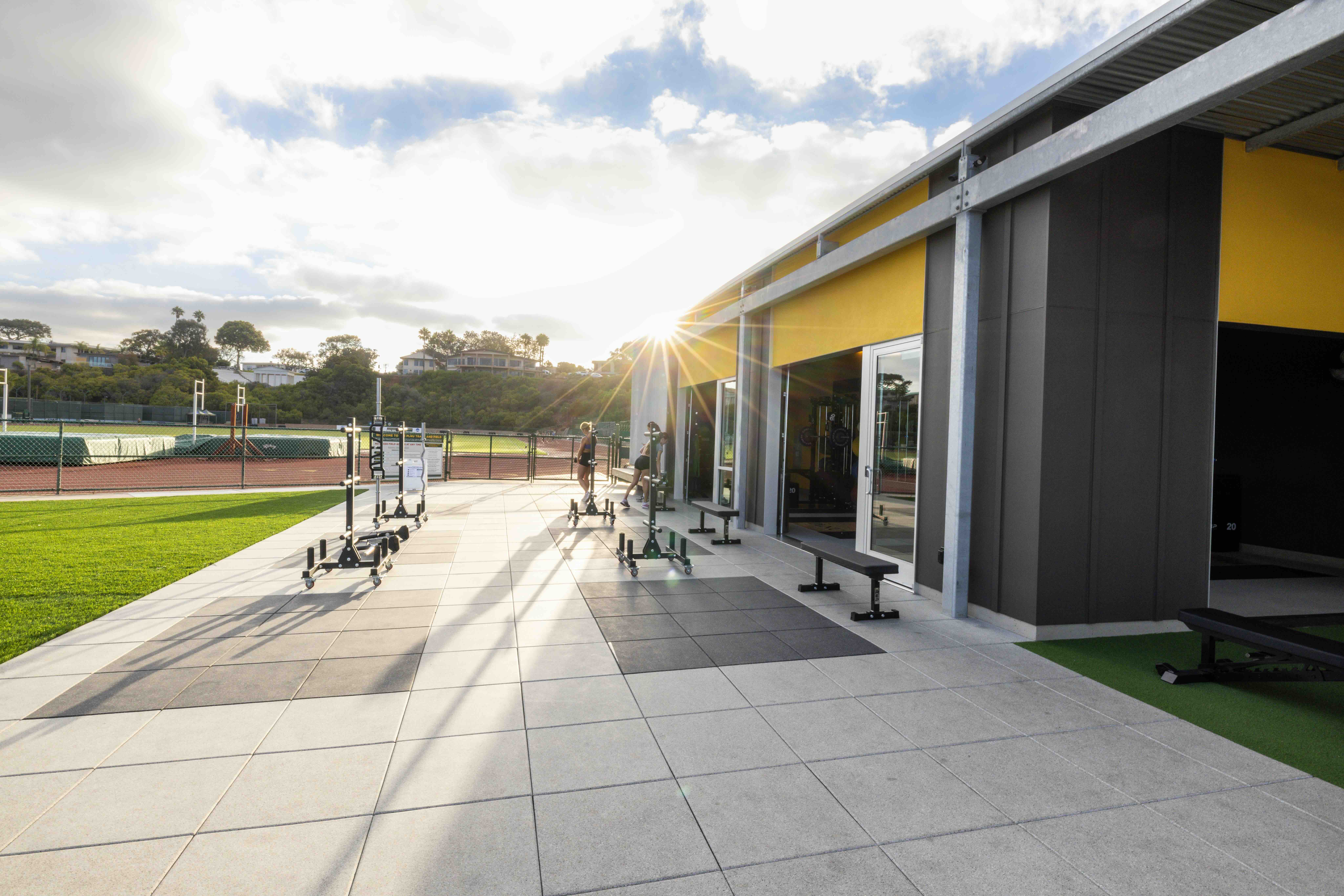 Lawrence Ryan Fitness Pavilion and outdoor training area illuminated by the setting sun.