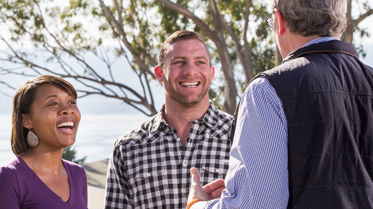 Todd Vance stands on the lawn of the Greek Amphitheater and talks with professor Jim Johnson