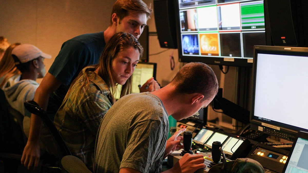 A group of Media Comm students work behind the scenes production in the PointTV studio 