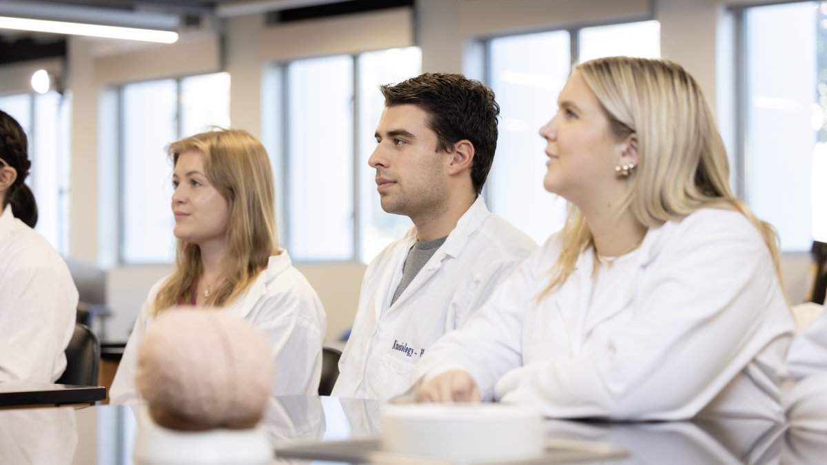 Students in anatomy lecture listen to class presentation.