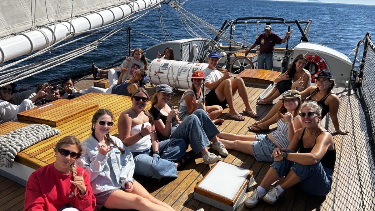 PLNU students relax on the deck of a sailboat on the Pacific Ocean for an outdoor education excursion. 