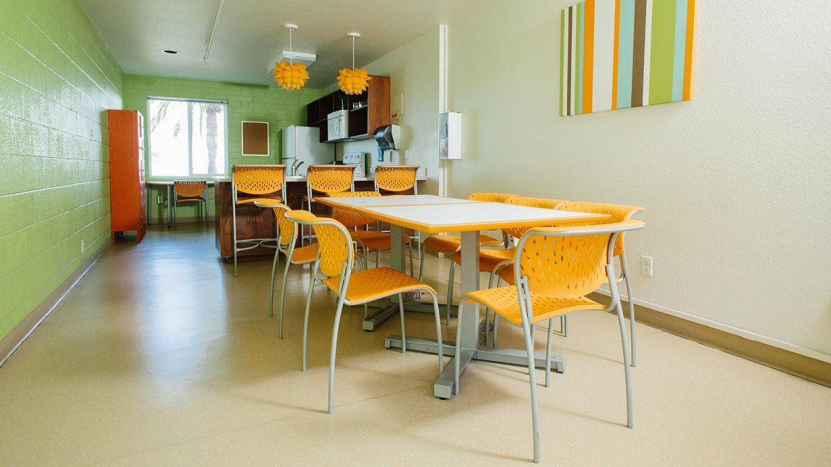 Finch's shared kitchen space is a colorful contrast of tables, chairs, and artwork on the walls.