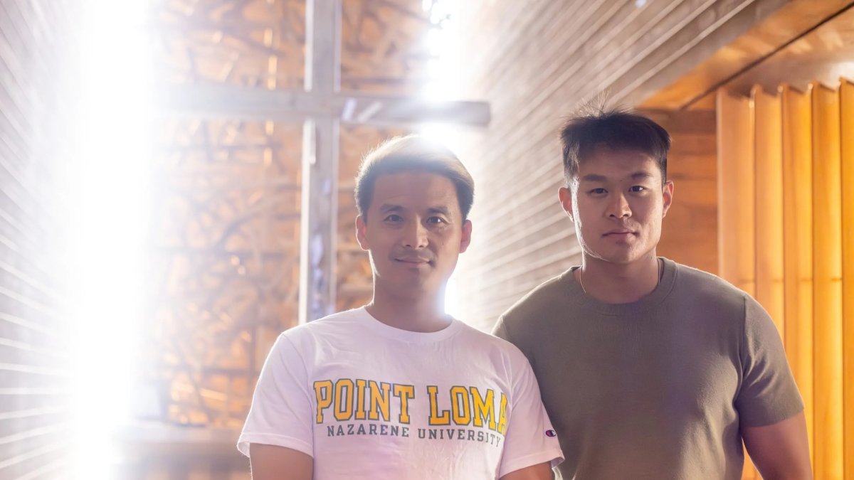 Two PLNU military students pose in front of the cross within the Prescott Prayer Chapel.