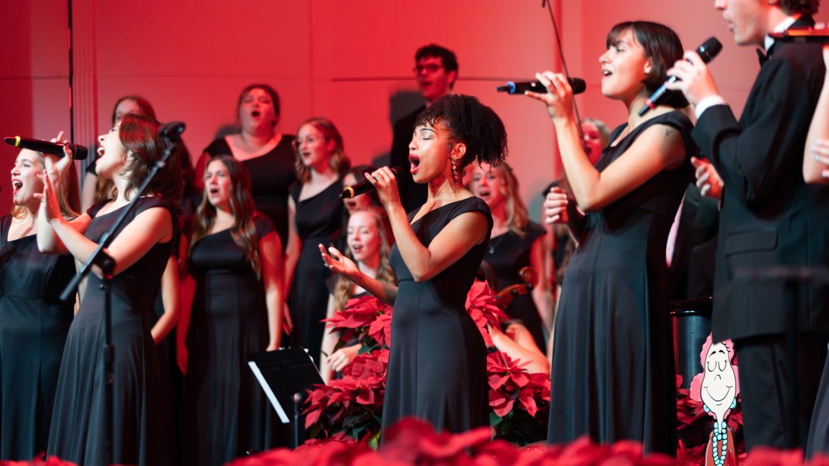 PLNU choir members sing into microphones during the Cider Celebration concert performance.
