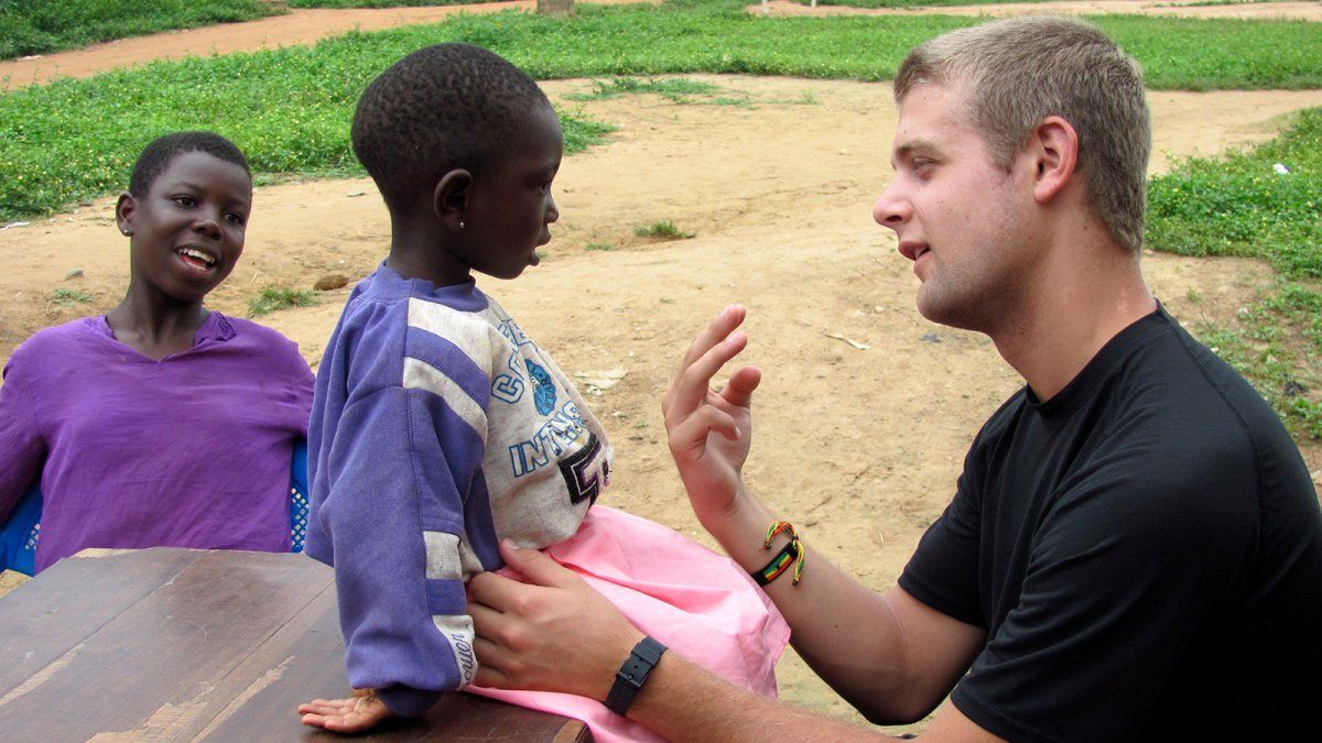 A PLNU student talks with a young girl in Ghana during a medical Loveworks trip.