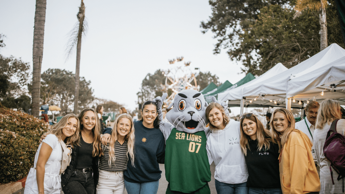 PLNU students posing with Splash the Sea Lion at the Homecoming Tailgate in 2019.