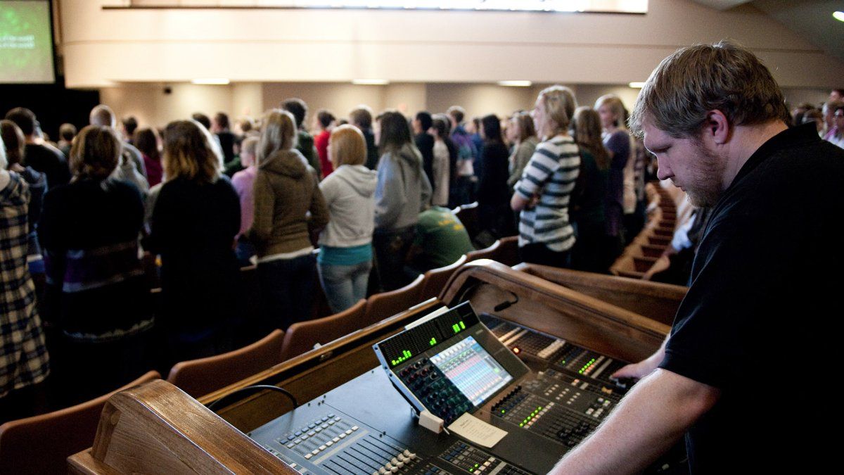 A student technician uses his talents monitoring sound levels to worship during chapel.