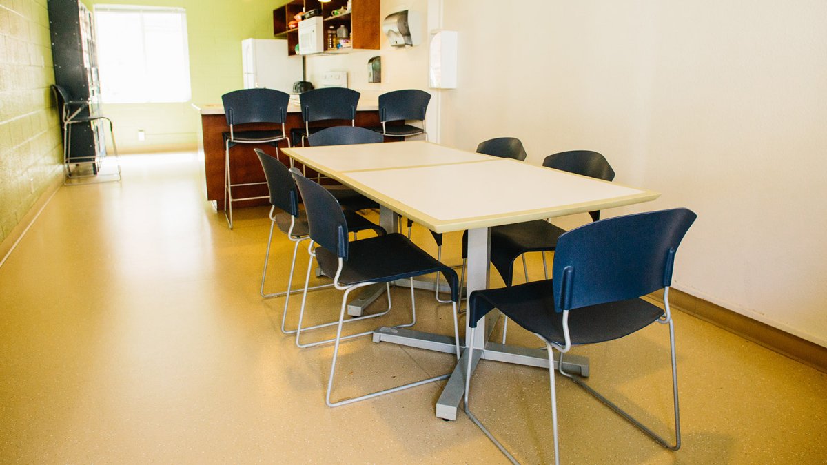 The kitchen space in Wiley, with multiple tables, chairs, and lockers for food storage.