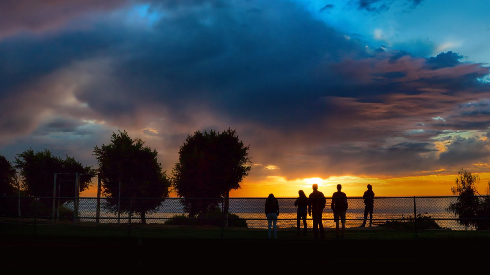 Students watch sunset from west side of track and field