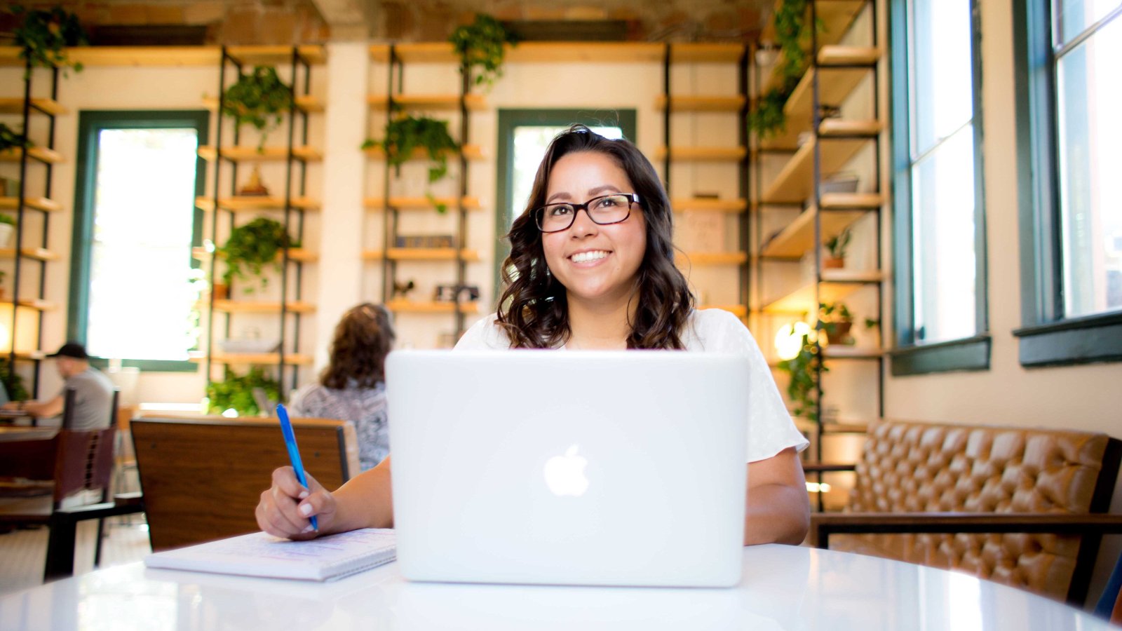 A woman works on her computer at a coffee shop