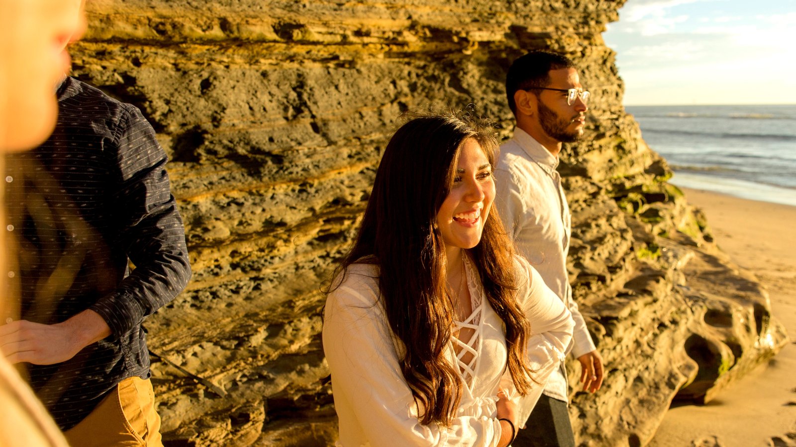 Undergraduate students on beach during sunset