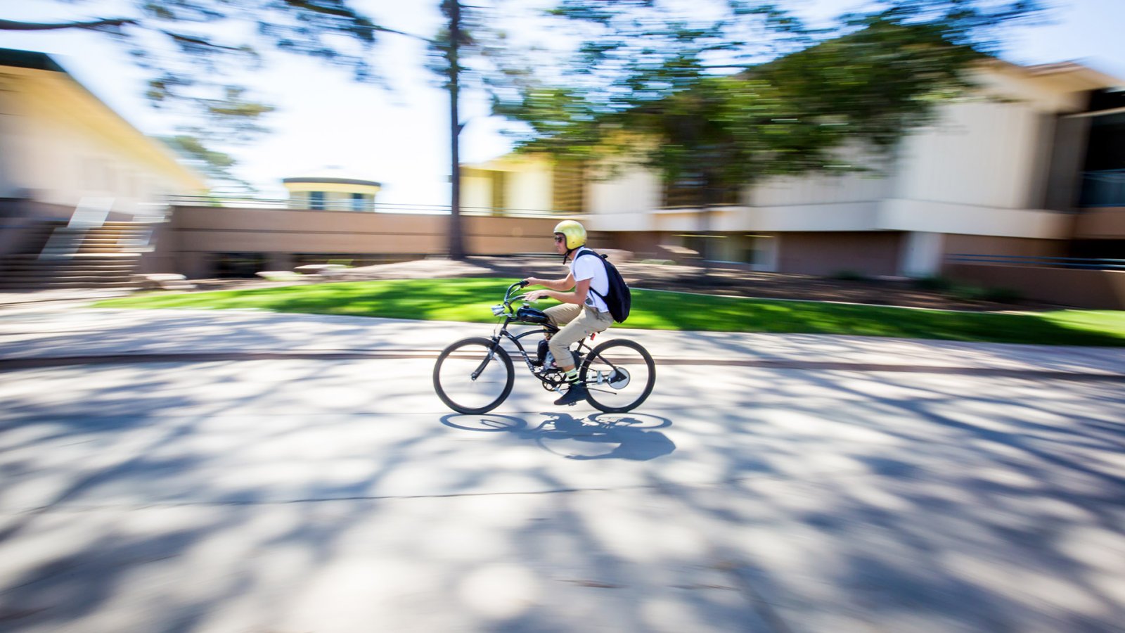 A student wizzes through campus on his bike