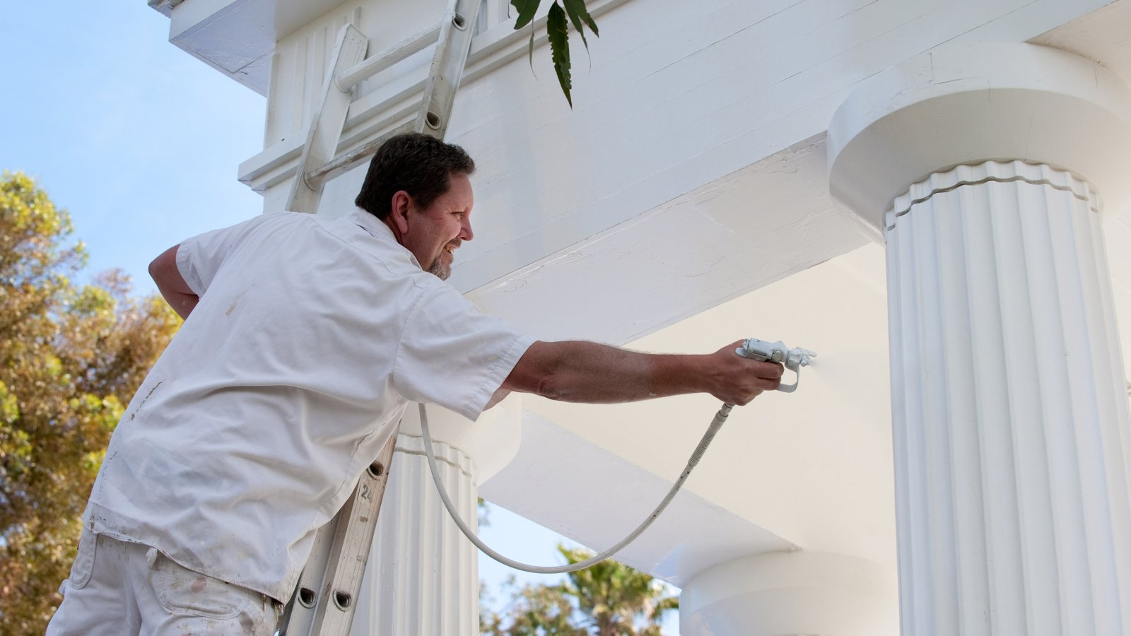 Campus facilities employee sprays a fresh coat of paint on the Greek amphitheater