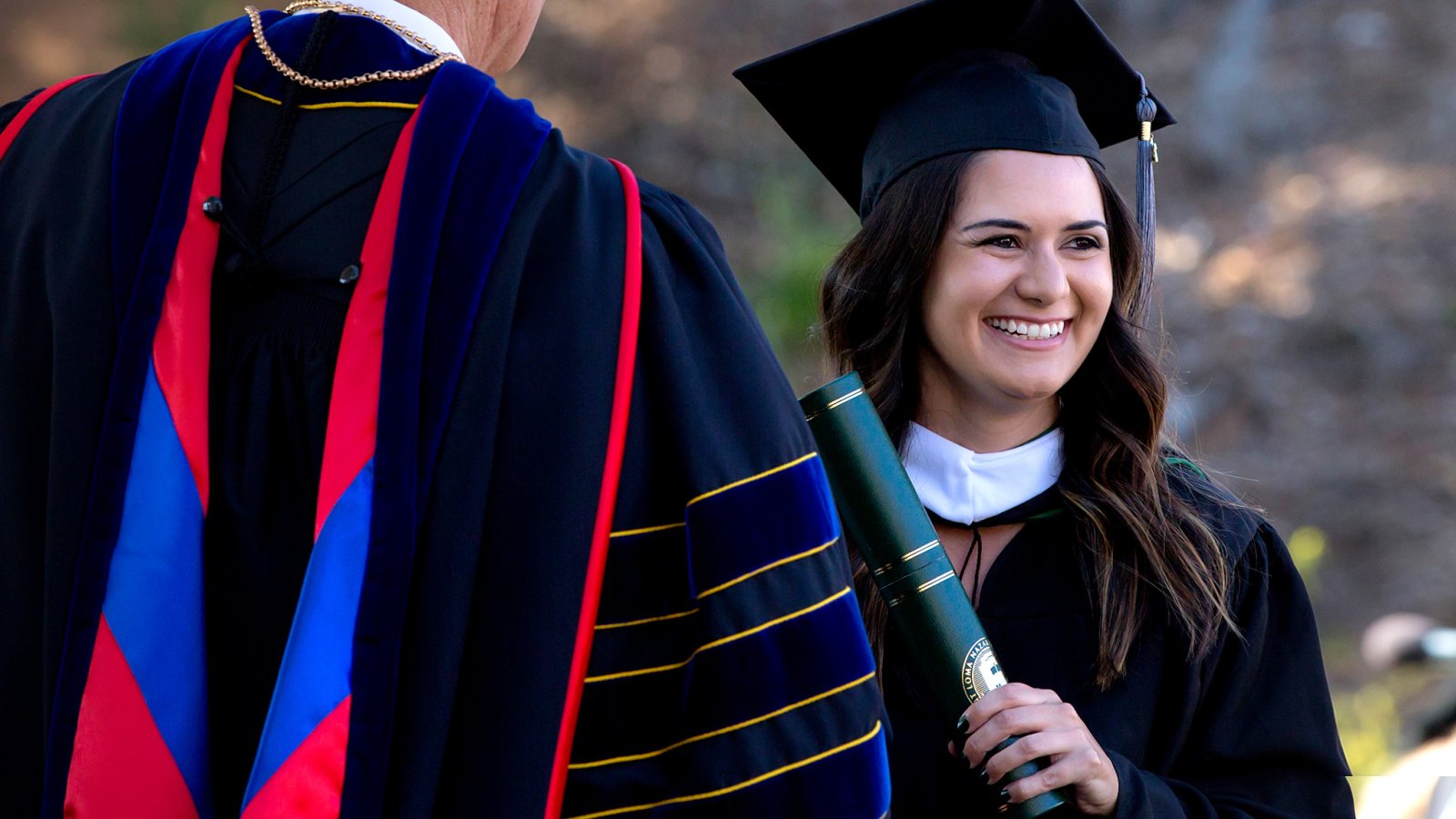 Female student receives her diploma from President Bob Brower