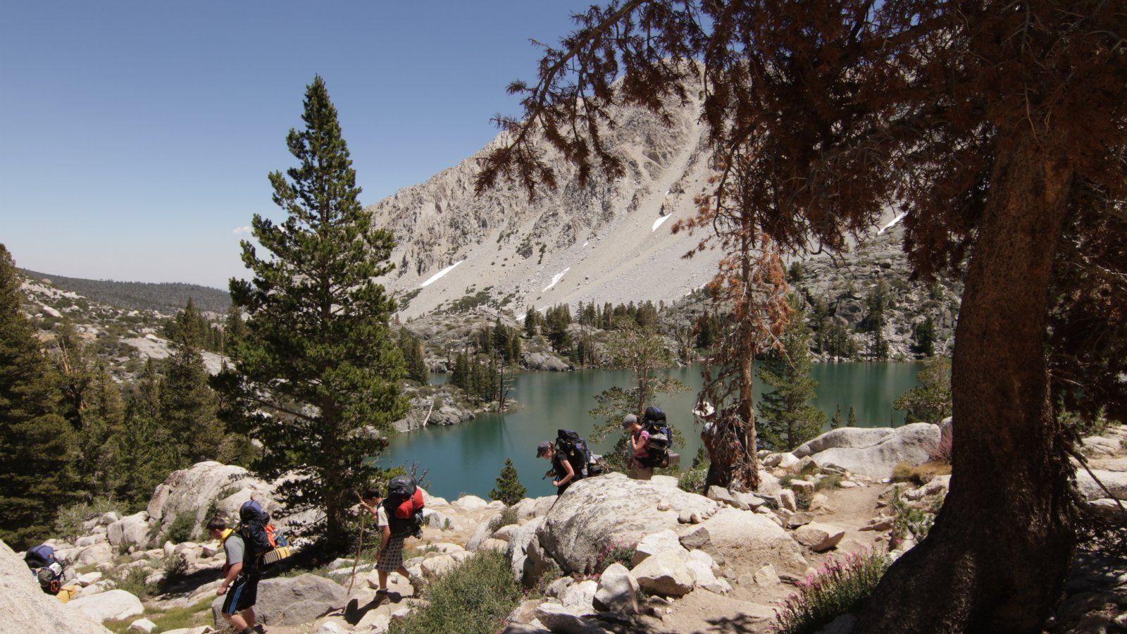 Students hike next to a lake