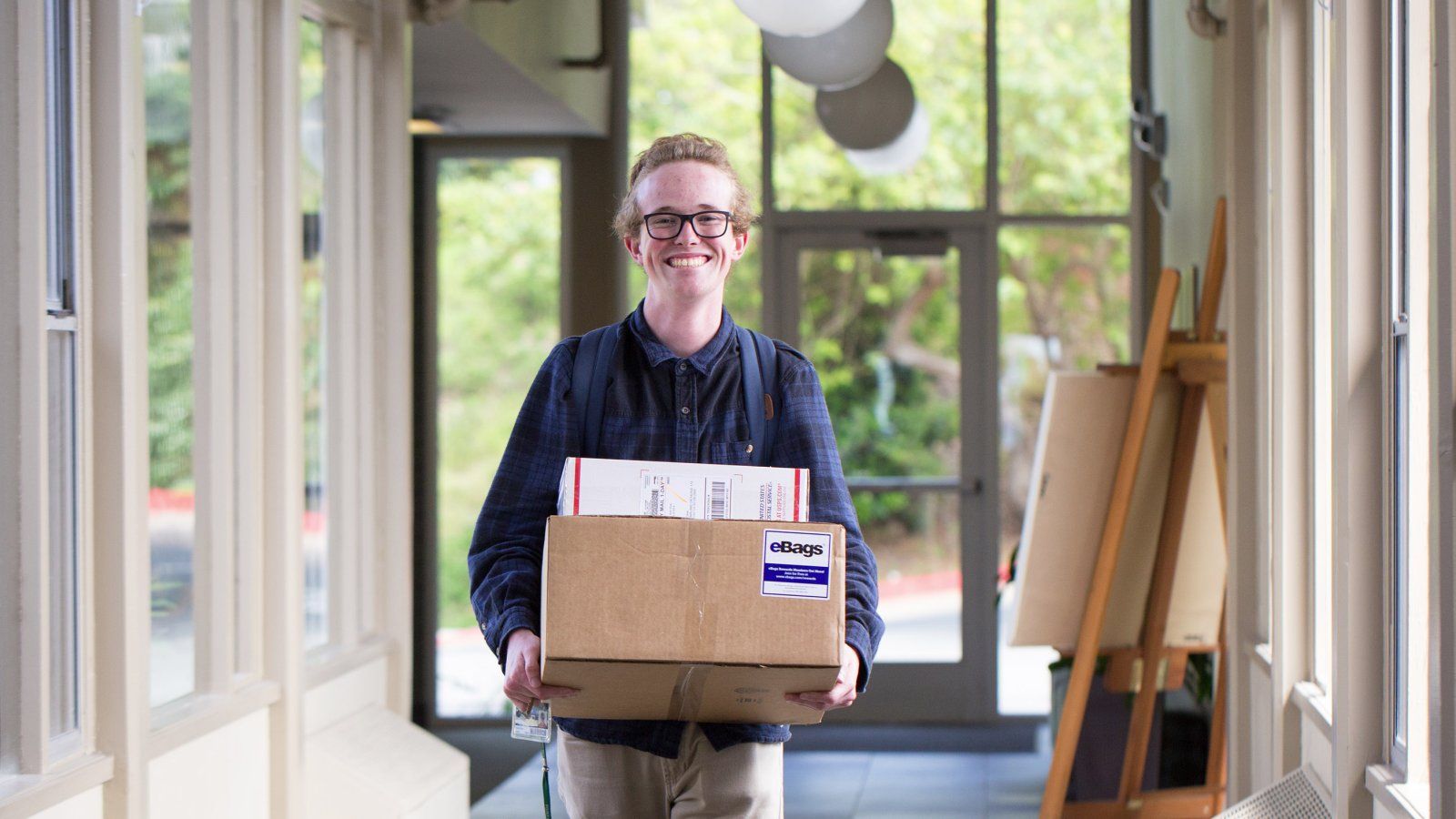 A student carries their mail in a residence hall