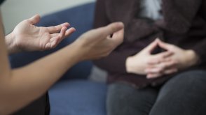 Counselor speaks with their patient on a couch. 