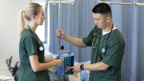 Two PLNU nursing students working in university medical labs using field's technology for assessment.
