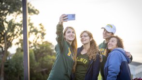 PLNU student taking selfie with her family in front of the Greek