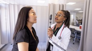PLNU nurse performs health examination on volunteer at university's nursing lab.