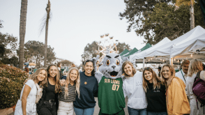 PLNU students posing with Splash the Sea Lion at the Homecoming Tailgate in 2019.