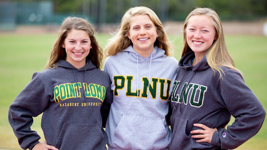 Three PLNU students show their school pride with PLNU sweatshirts as they run on the track.
