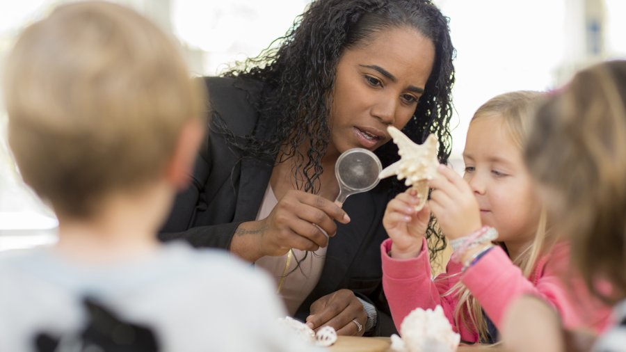An excellent teacher looking at a starfish with a student 