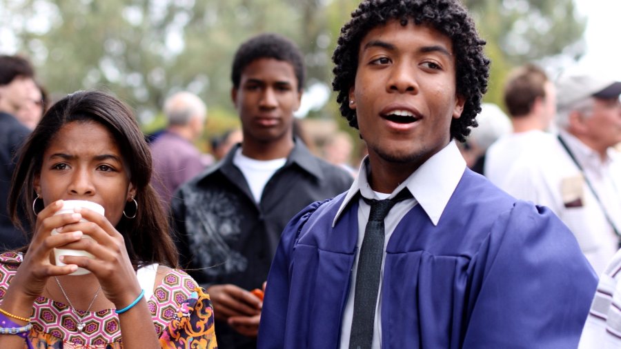 Male student in graduation robes waits for the ceremony to begin