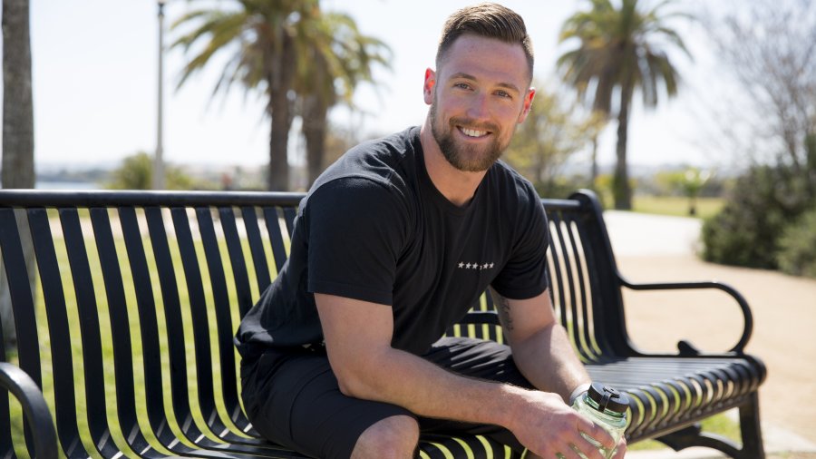 student sitting on a bench smiling at the camera