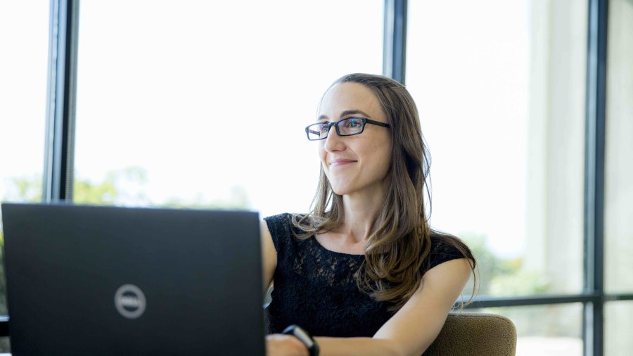 PLNU student looks up from work on her laptop