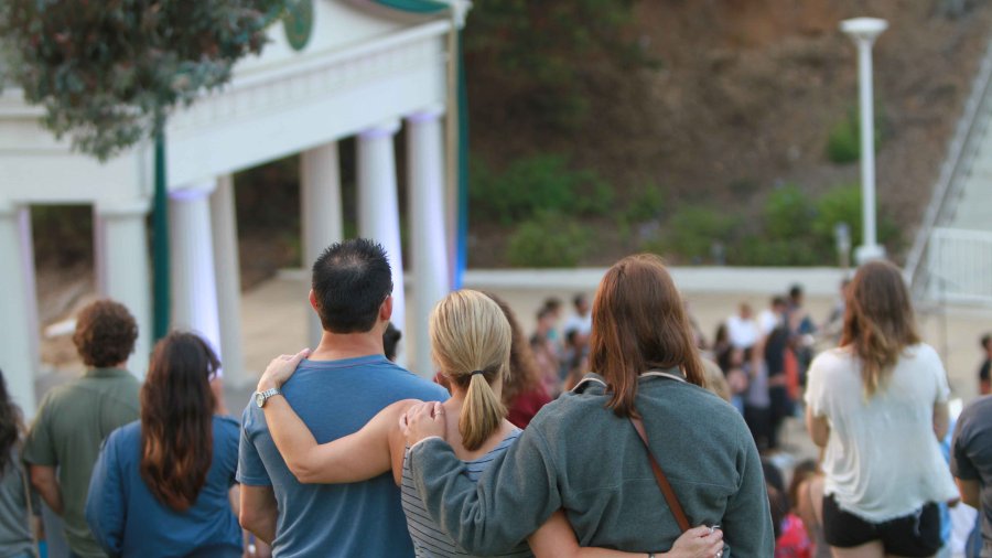 A family hugs at a PLNU service in the Greek.