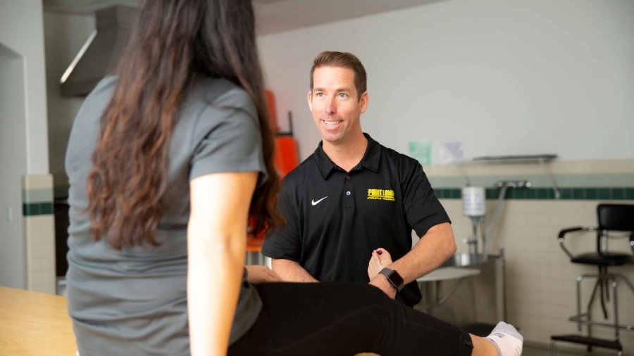 Man works on a patients ankle in therapy