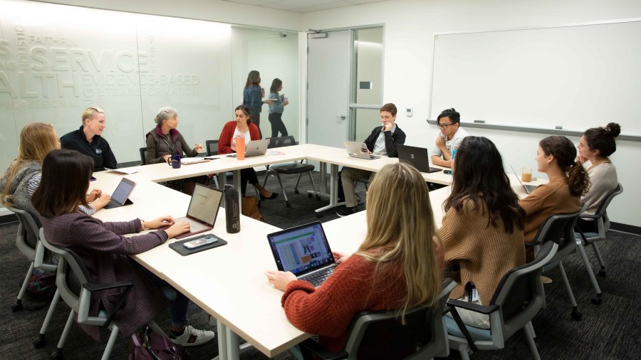 Group of adult students gather in a circle in a PLNU class