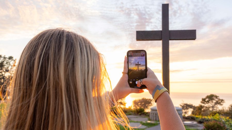 Girl takes photo of the PLNU cross on campus
