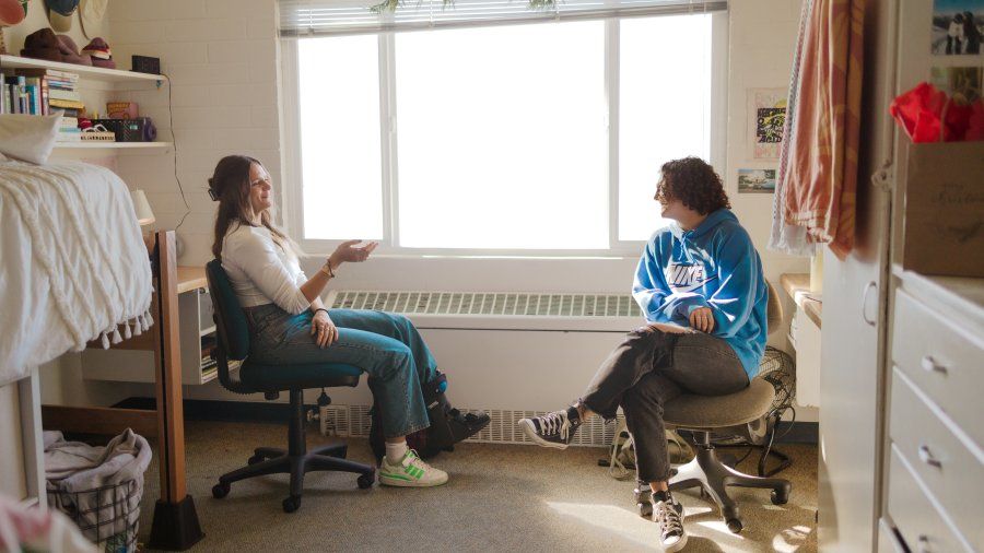 Two students chat in their dorm room