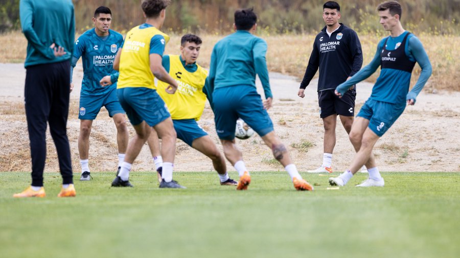 Mens soccer players pass the ball around at practice