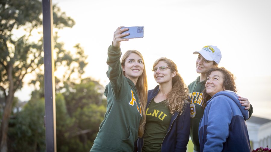 PLNU student taking selfie with her family in front of the Greek