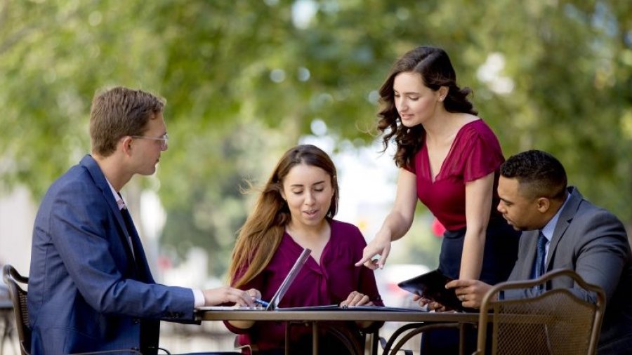 A group of businesspeople meet in a park