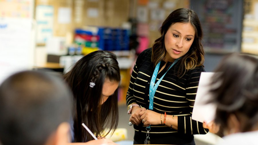 A woman working with students.
