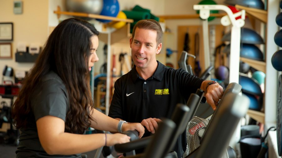 Kinesiology student learnings how to train on exercise bike